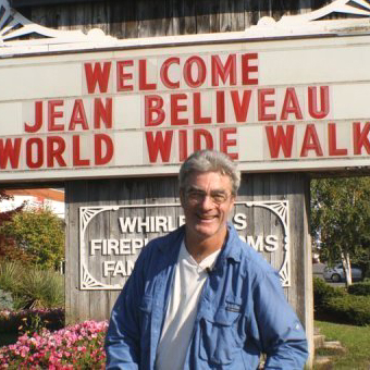 Jean-Beliveau-poses-in-front-of-a-welcome-sign-in-Ontario